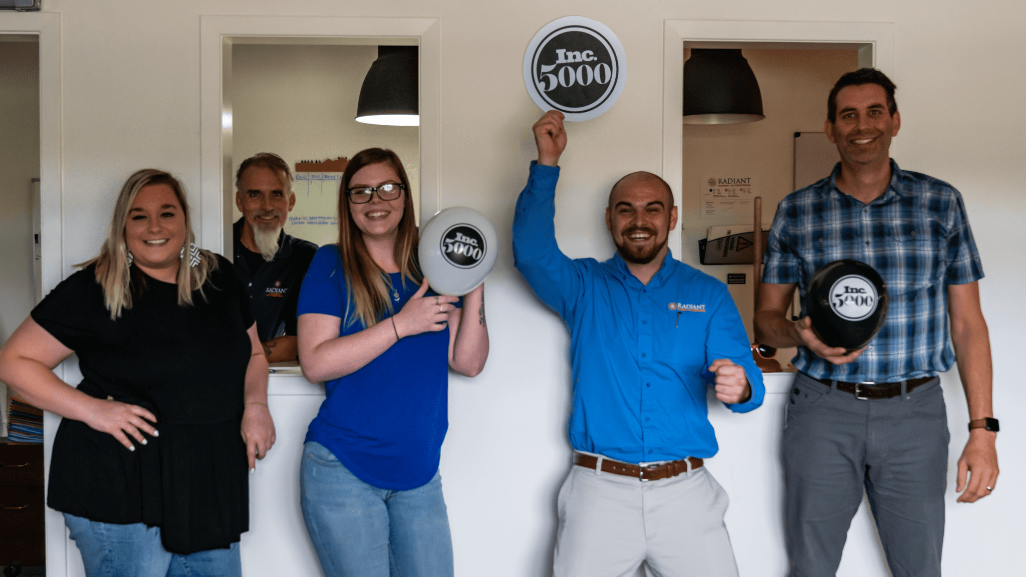 Employees of Radiant Plumbing, Air Conditioning, & Electrical waiving INC 500 balloons in celebration