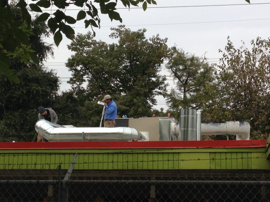 Radiant Technicians working on the roof HVAC system of Pets Alive in Austin
