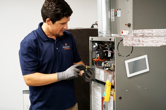 Man using tools to do maintenance on a heating system