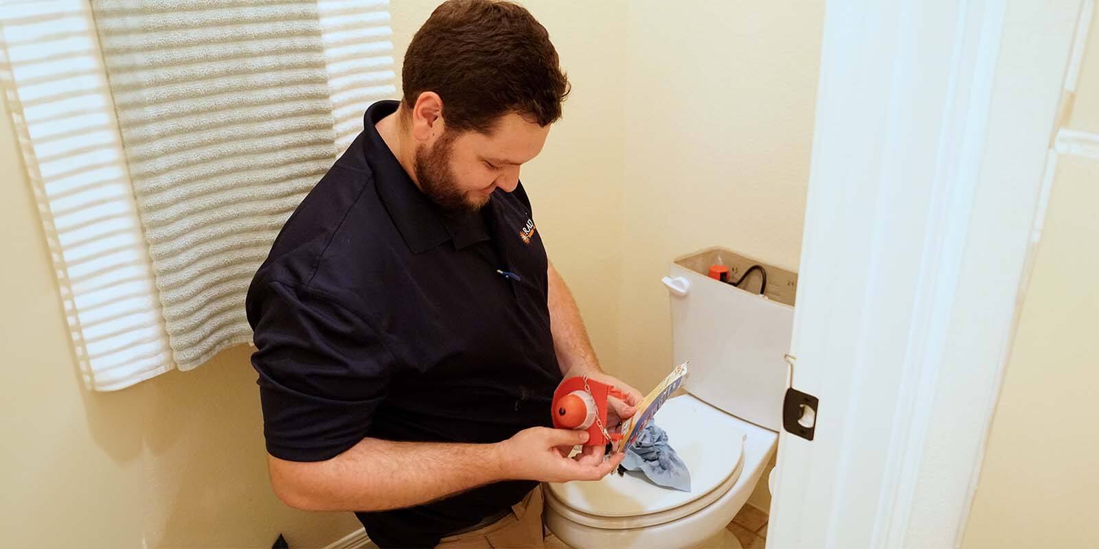 A Radiant technician working on a toilet
