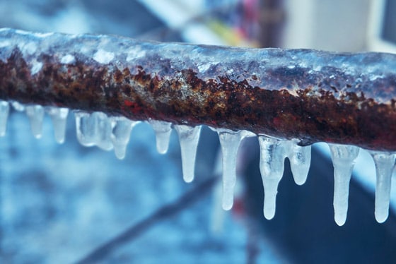 up close image of ice formed around a copper pipe