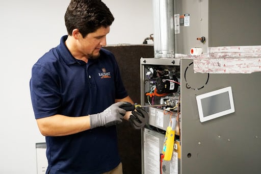 Radiant technician working on a furnace in a home