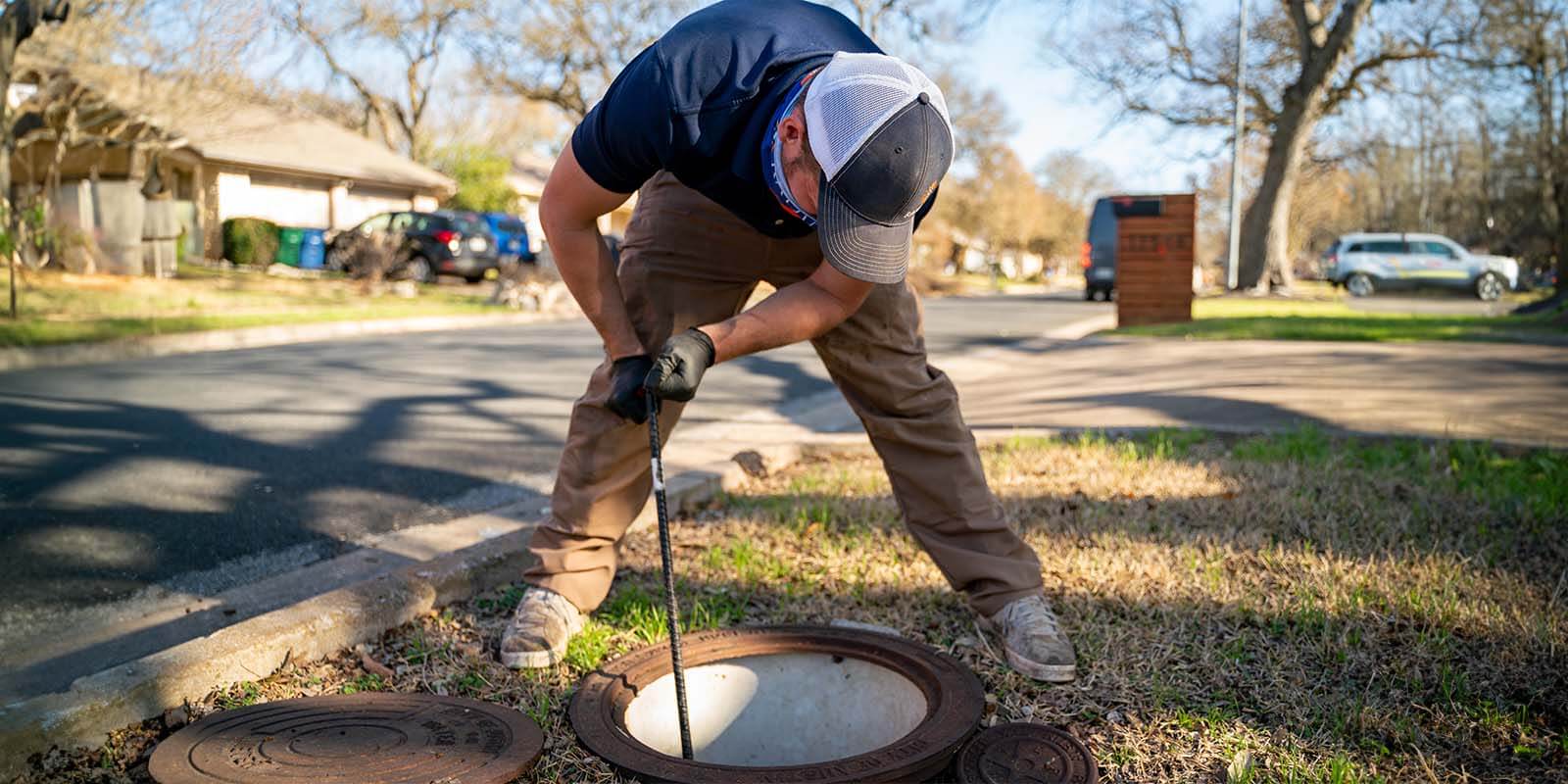Radiant technician clearing out a sewer drain in the yard