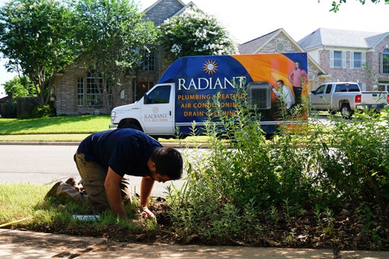 Radiant technician inspects irrigation system in yard