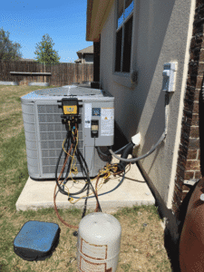 Newly installed Carrier air conditioner with gauges connected during system startup in Pflugerville TX