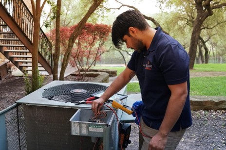 Radiant technician inspecting an outdoor HVAC unit