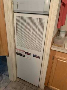Air handler closet with front panel closed after installation and system checks.