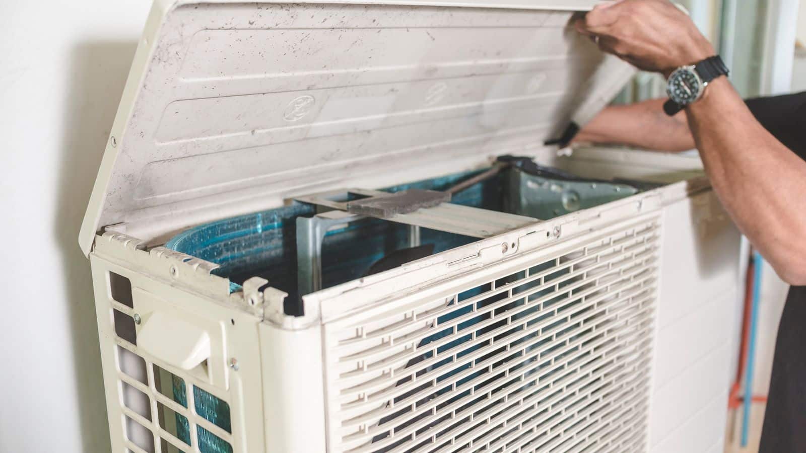 A person performing maintenance on a heat pump system