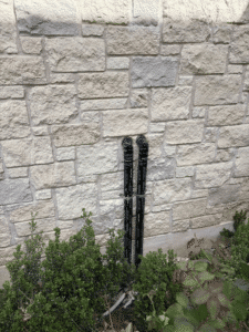 Exterior venting and plumbing lines for tankless water heaters installed along home exterior