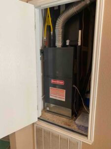 A Goodman furnace blower inside an HVAC closet in a home