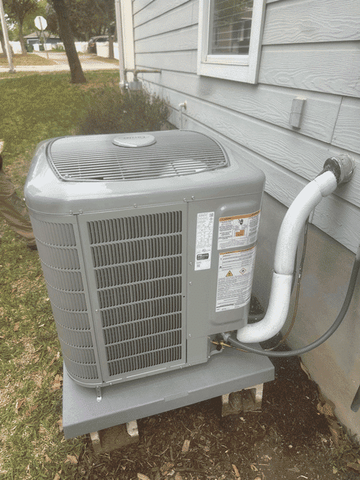 Newly installed heat pump condenser on raised pad next to home in Cedar Park TX