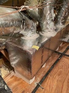 Newly built insulated supply plenum with flex duct connections sealed with mastic for airflow efficiency.