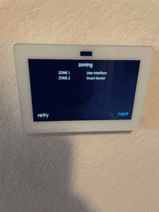 Smart thermostat displaying zoning setup for upstairs and downstairs control in Austin home